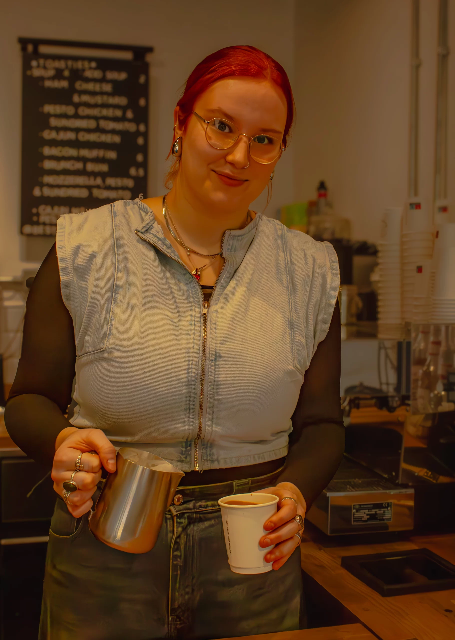 Barista pouring coffee at Aura Café